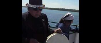 Dennis Banks and Carlos Sauer singing in the boat with friends In Michigan, USA.